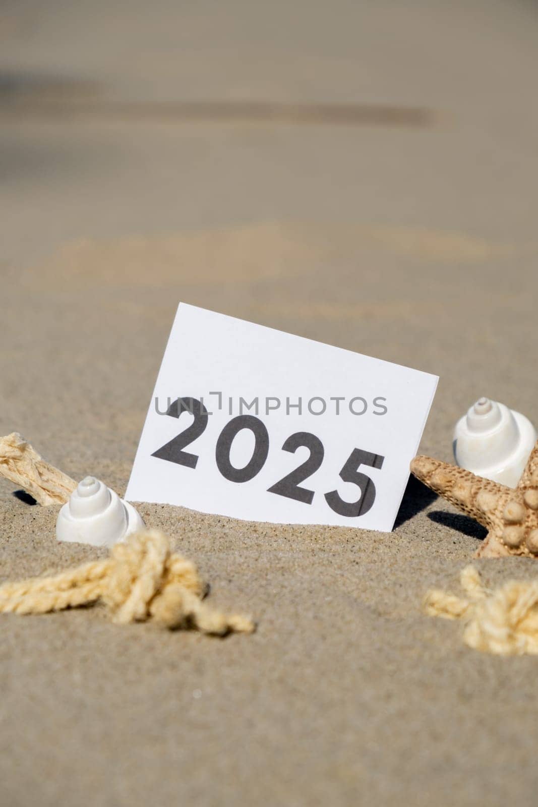 2025 text start new year symbol on paper greeting card on background of starfish summer vacation decor. Sandy beach sun coast. Holiday concept postcard. Getting away Travel Business concept