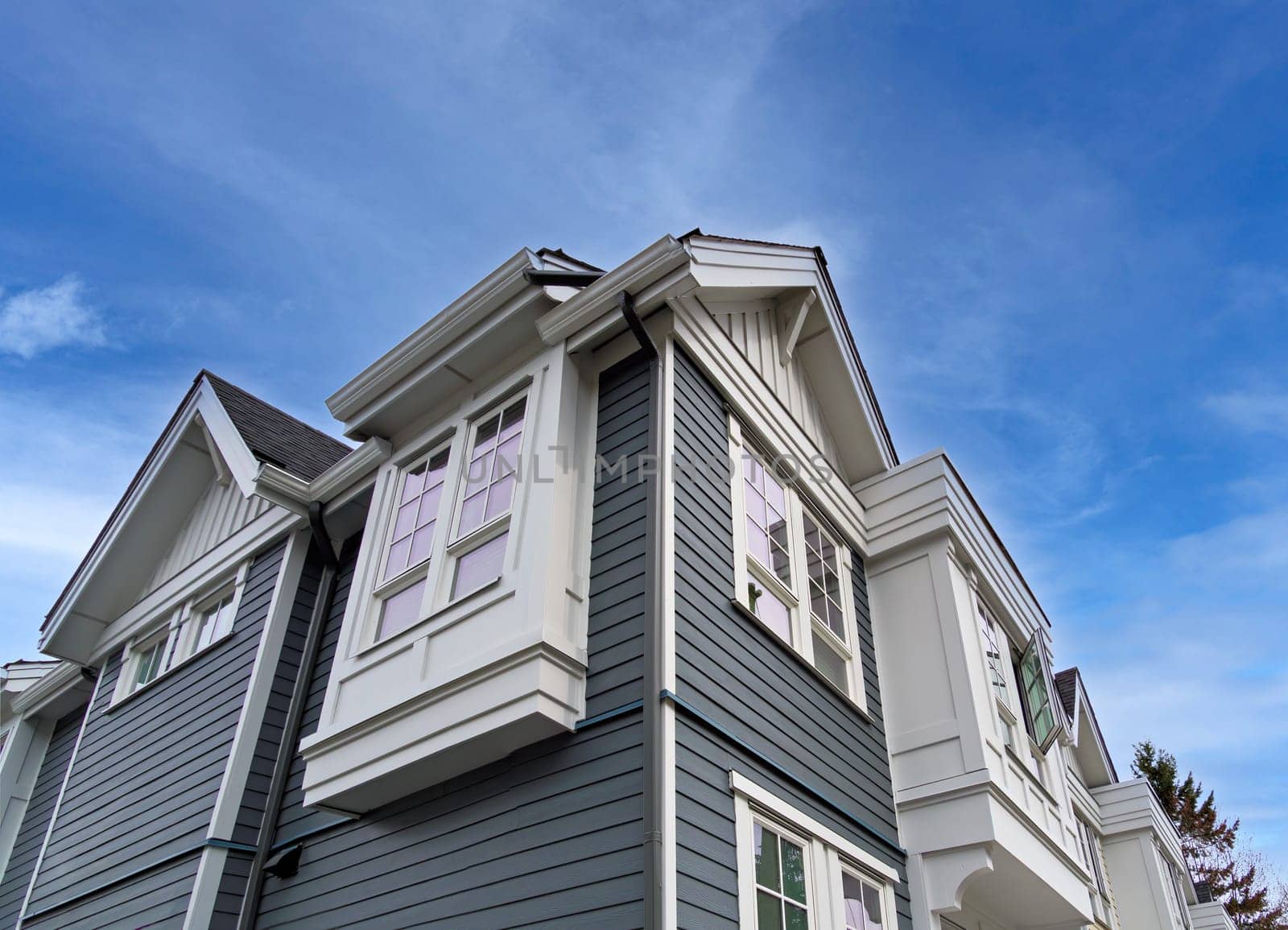 Top of residential townhouse on blue sky background.