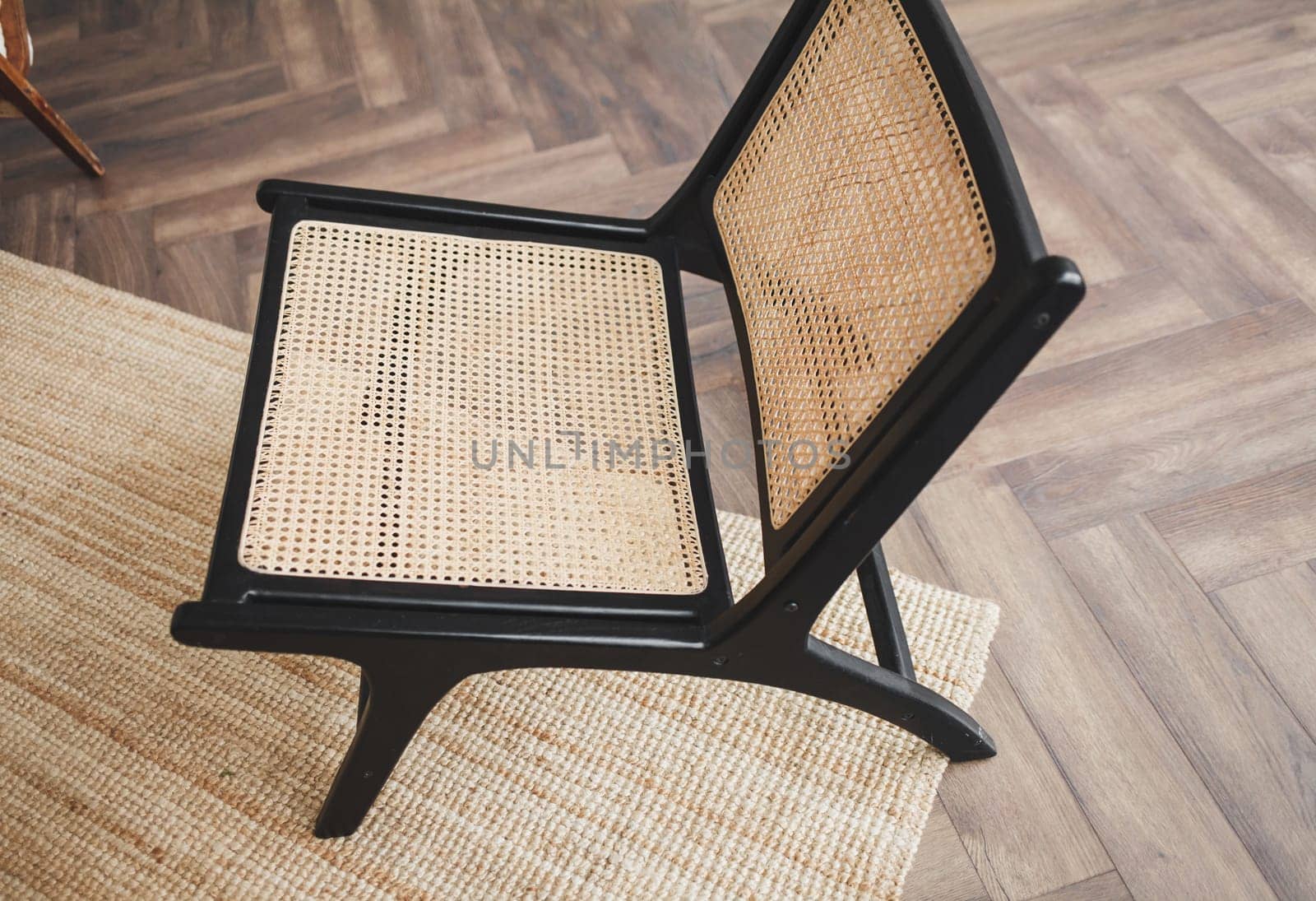 classic wicker chair on the carpet in a stylish interior