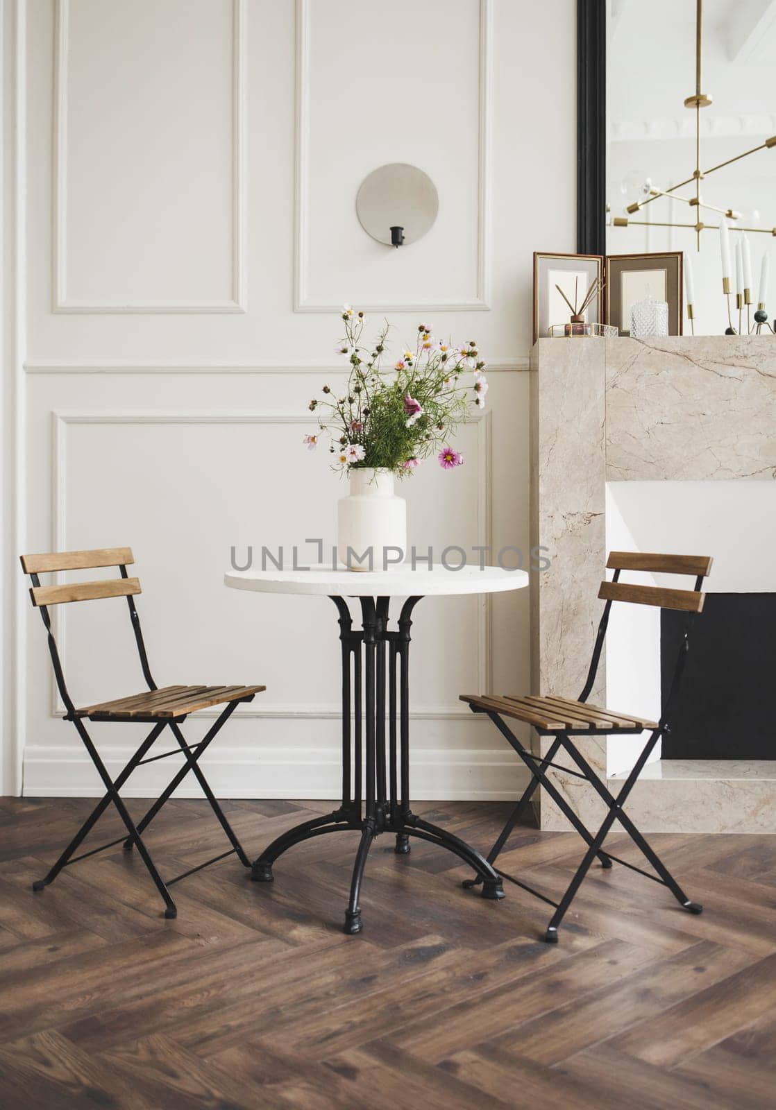 side table and comfortable chairs in a stylish minimalist interior of the apartment in bright colors