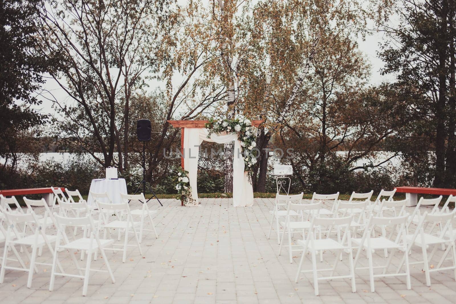 Wedding arch decorated with cloth and flowers outdoors. Beautiful wedding set up