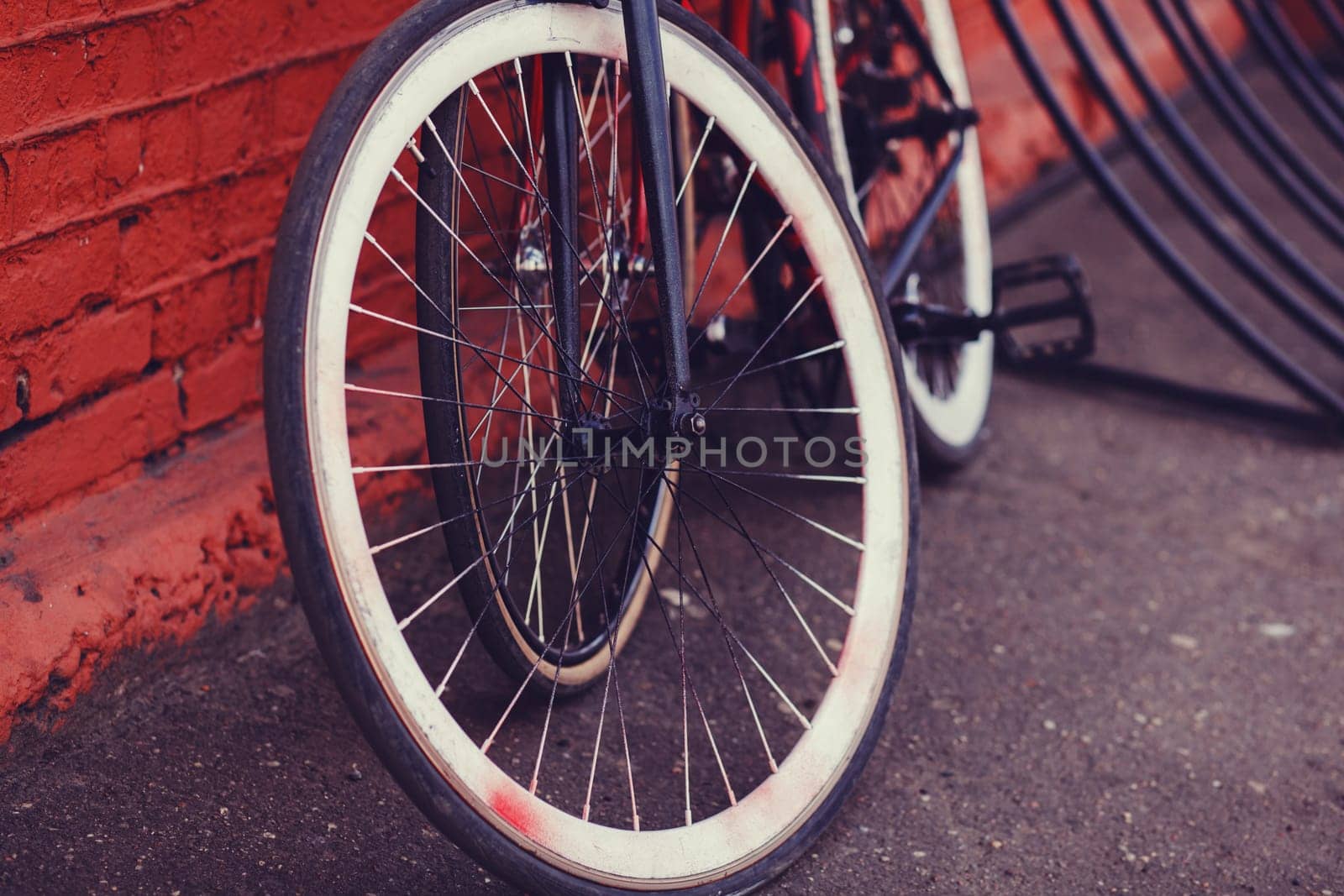 Two bicycles parked next to industrial red building