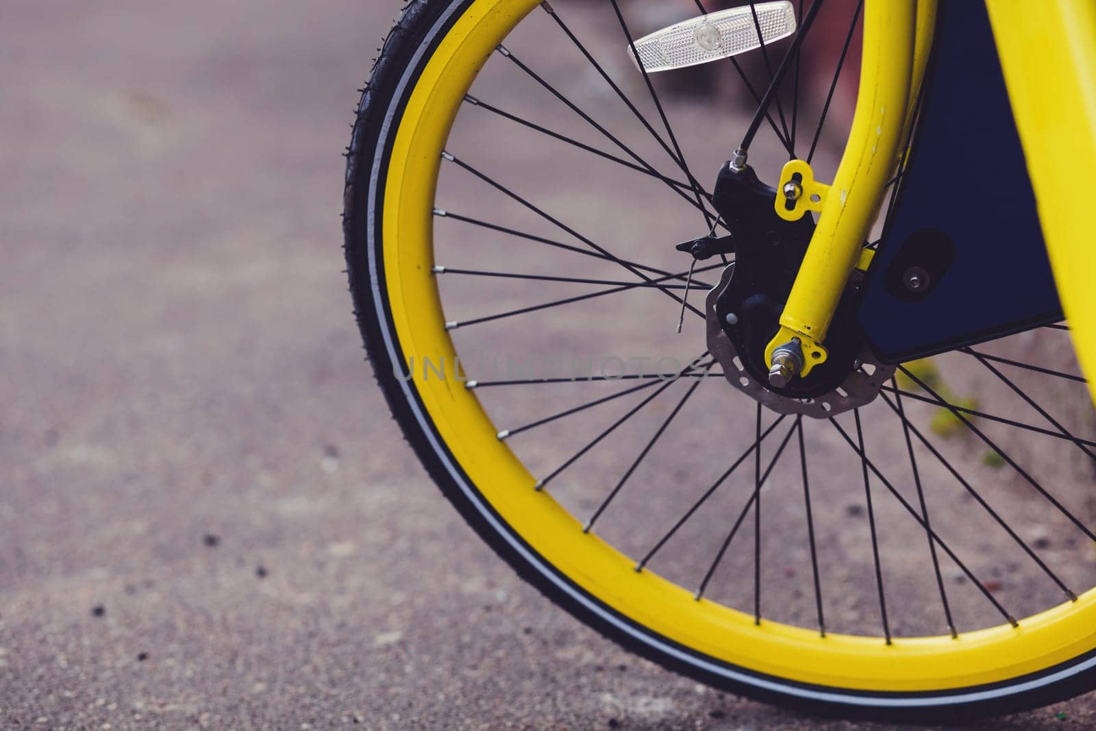 vintage yellow bicycle wheel in the city. Bicycle rentals