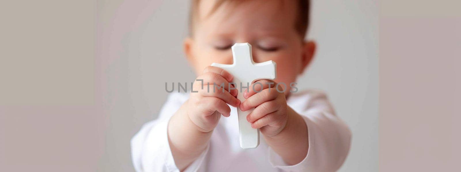 Baptism of a child cross in hands. Selective focus. Kid.