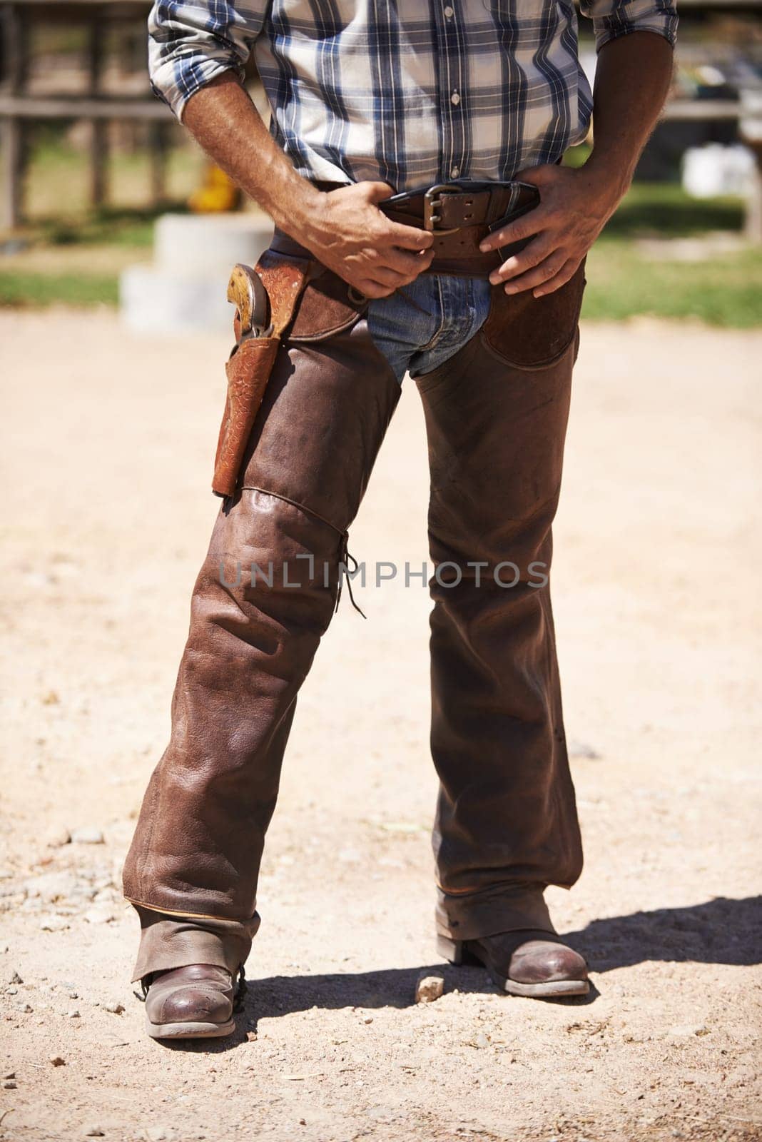 Farm, nature and legs of cowboy on ranch with weapon for horse, cows and rodeo animals for agriculture. Farming, costume and closeup of man in environment, countryside and working outdoors in Texas.