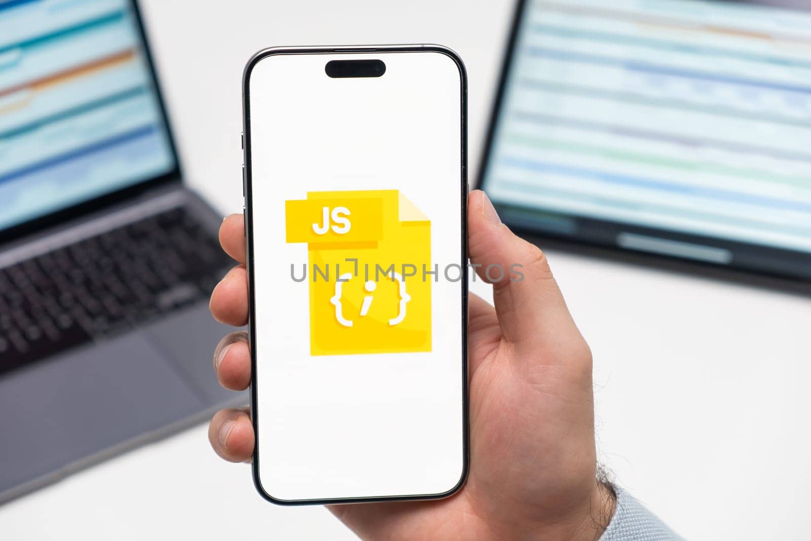 PRAGUE, CZECH REPUBLIC - JANUARY 21 2024: JS logo on the screen of smartphone in mans hand on the workplace background.