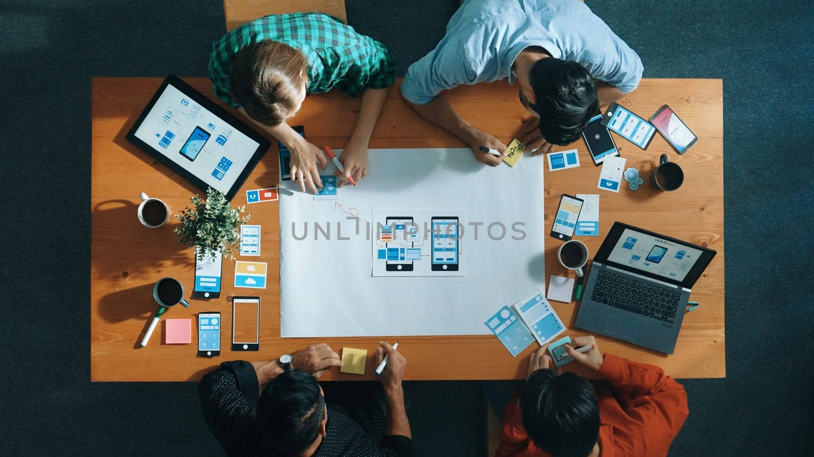 Top view of developer team sharing idea of Ux Ui design by using mind map. Top down view of group of business people working together to brainstorm or plan mobile phone interface app. Convocation.