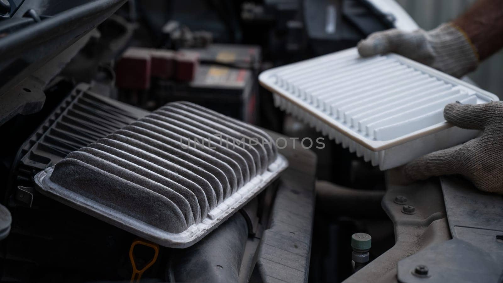 The master changes the air filter in the car engine