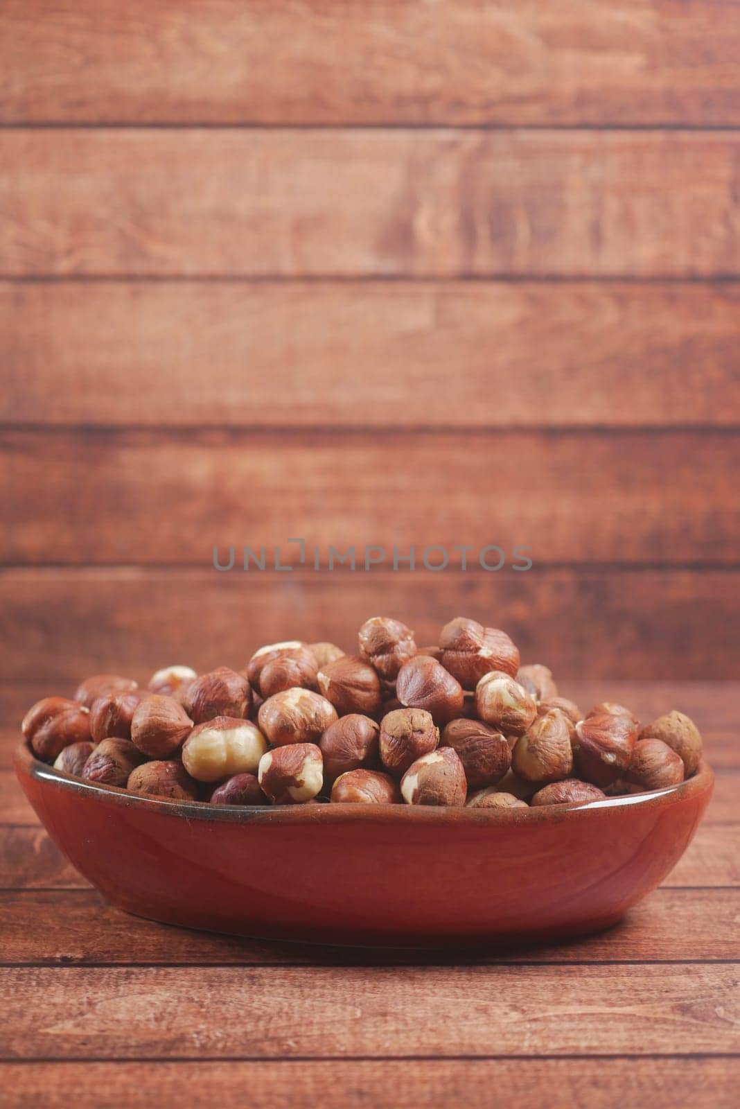 hazelnuts in a container on black background