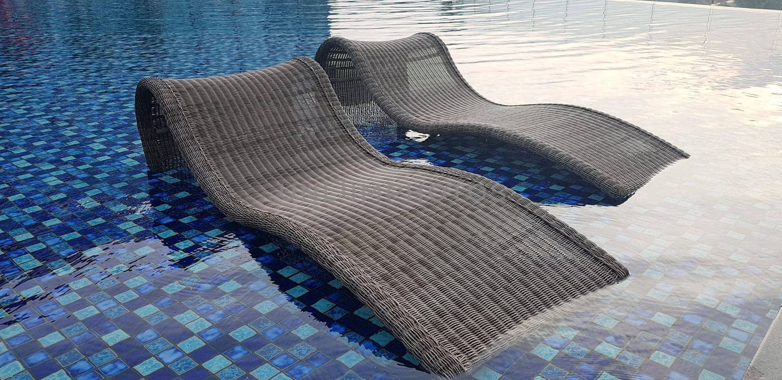 relax deck chair by the blue pool at swimming pool in luxury spa resort or villa Tourism industry crisis after covid 19 coronavirus pandemic Travel lifestyle on family summer vacation