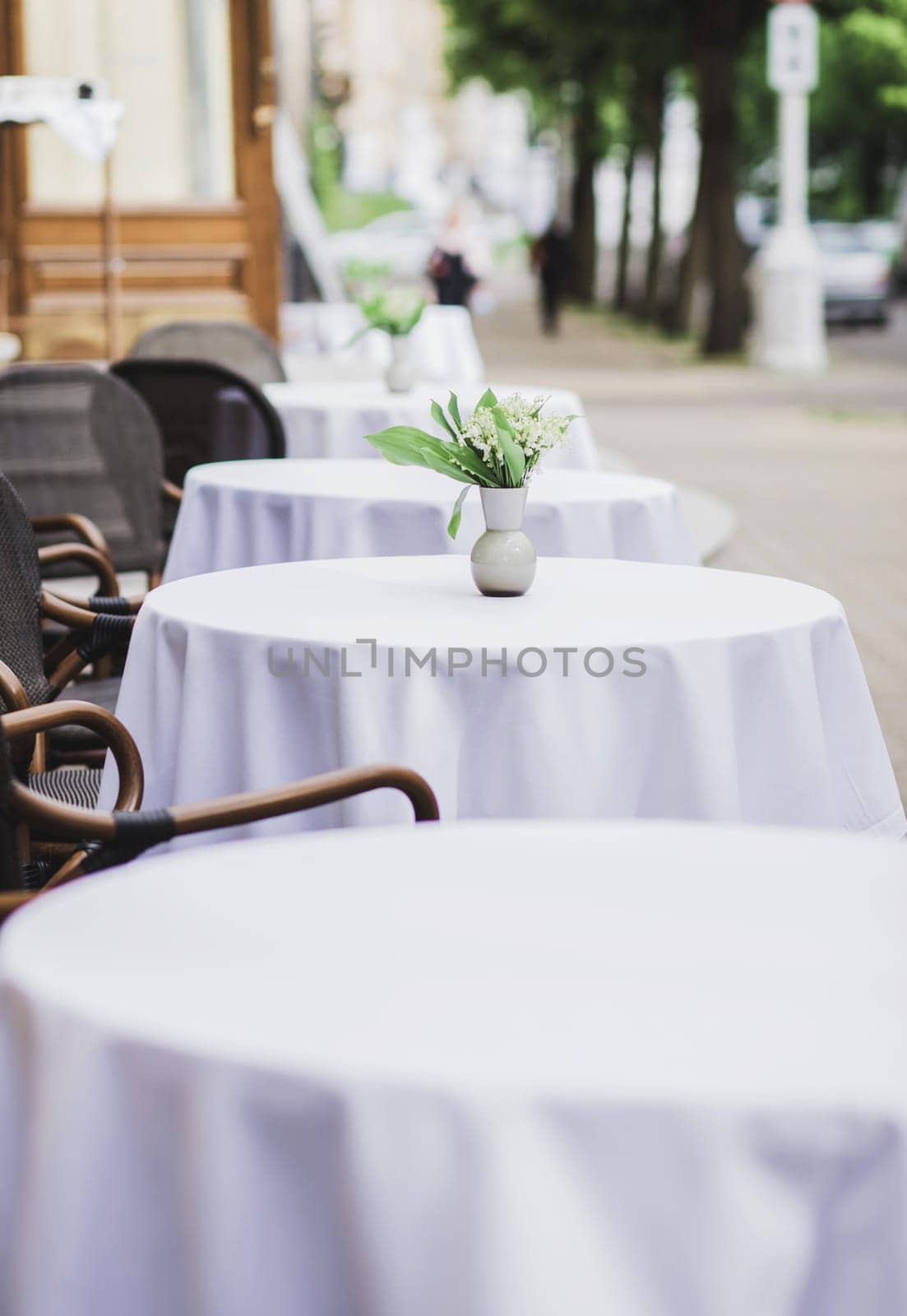 row of empty outdoor cafe tables. street terrace