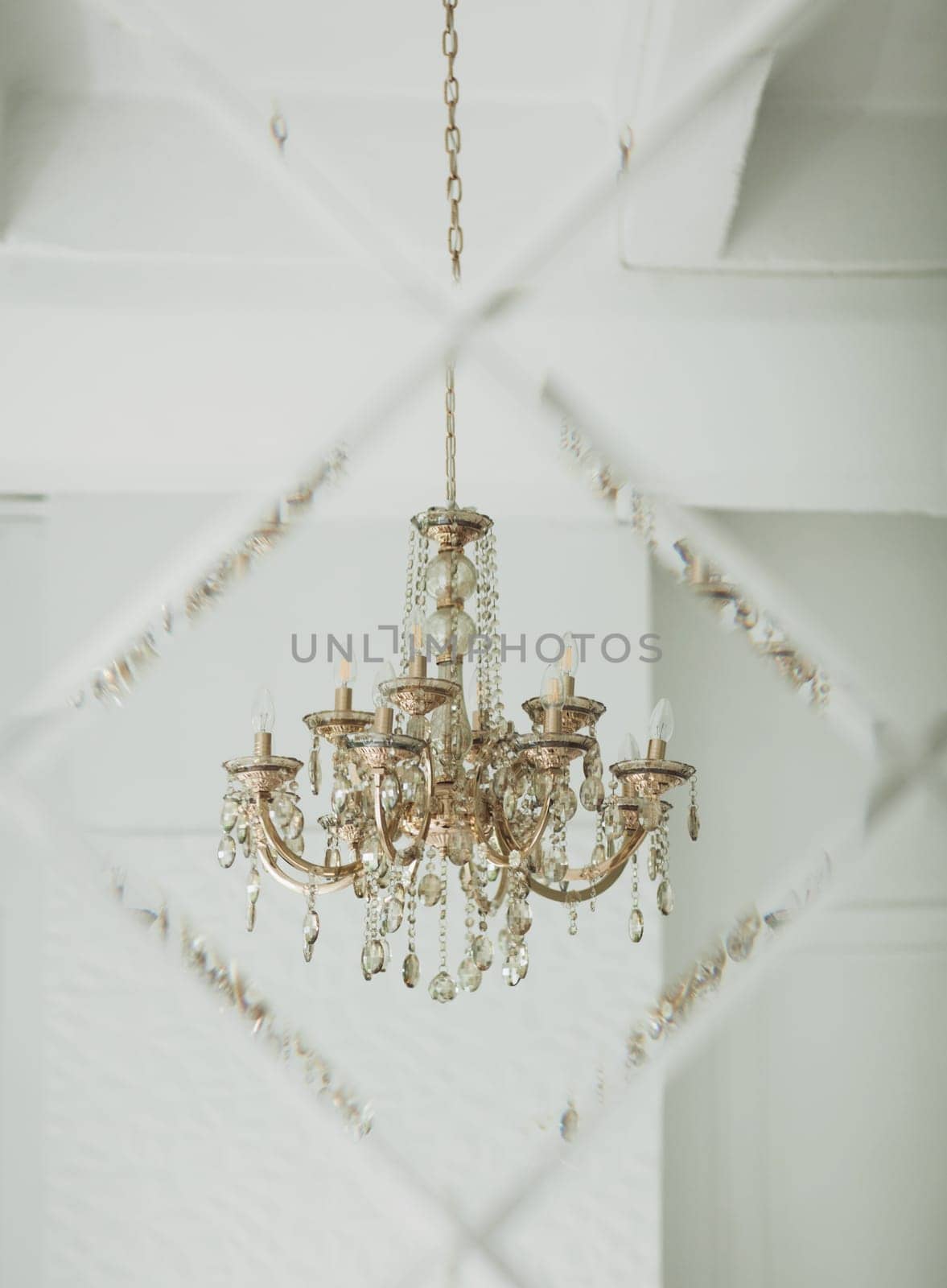 antique classic chandelier is reflected in the mirror of the apartment