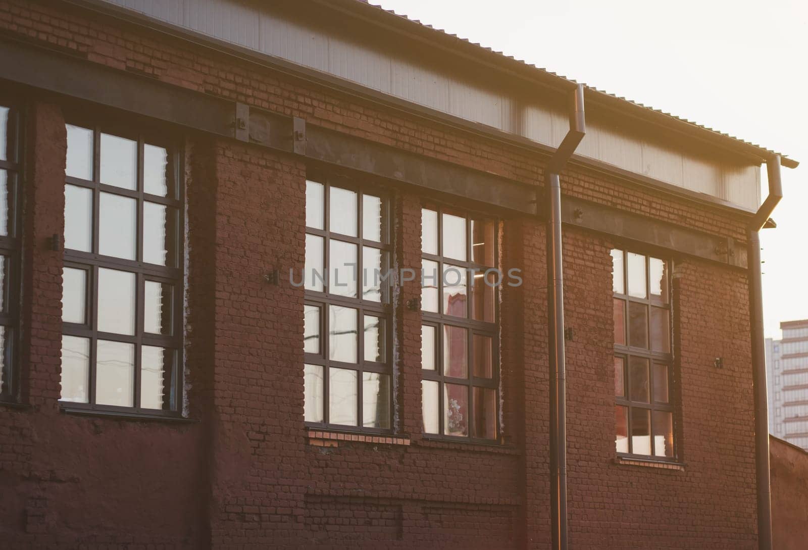 old brick building with windows at sunset