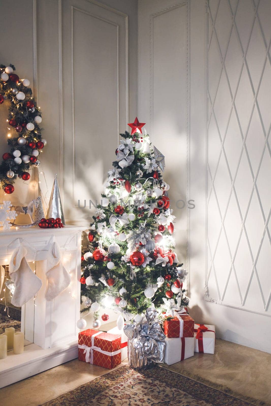 evening living room with Christmas tree decorated with toys and garlands