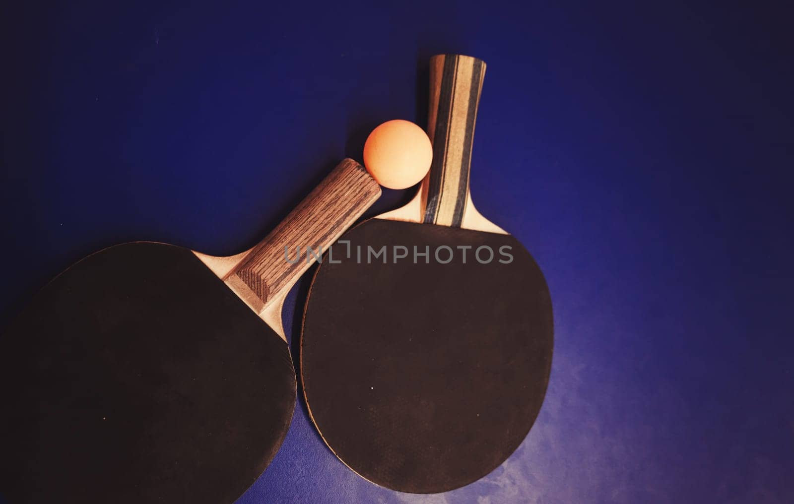 Two table tennis (ping pong) rackets and balls on table