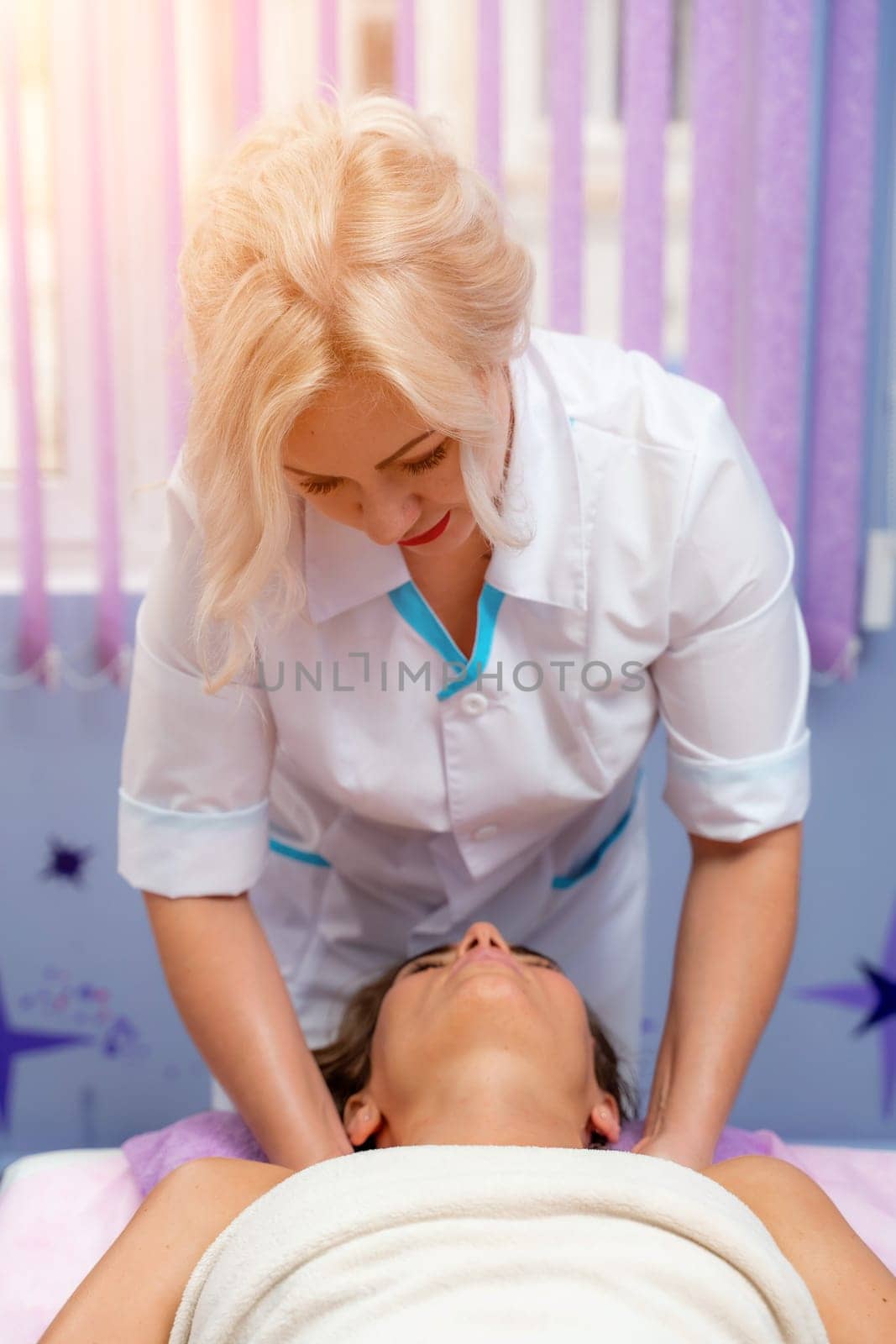 Masseur woman massages her shoulders. Woman getting a massage at the spa.