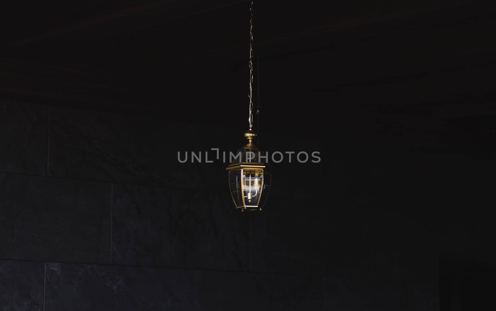 Modern style gold decoration lamp against dark wall.