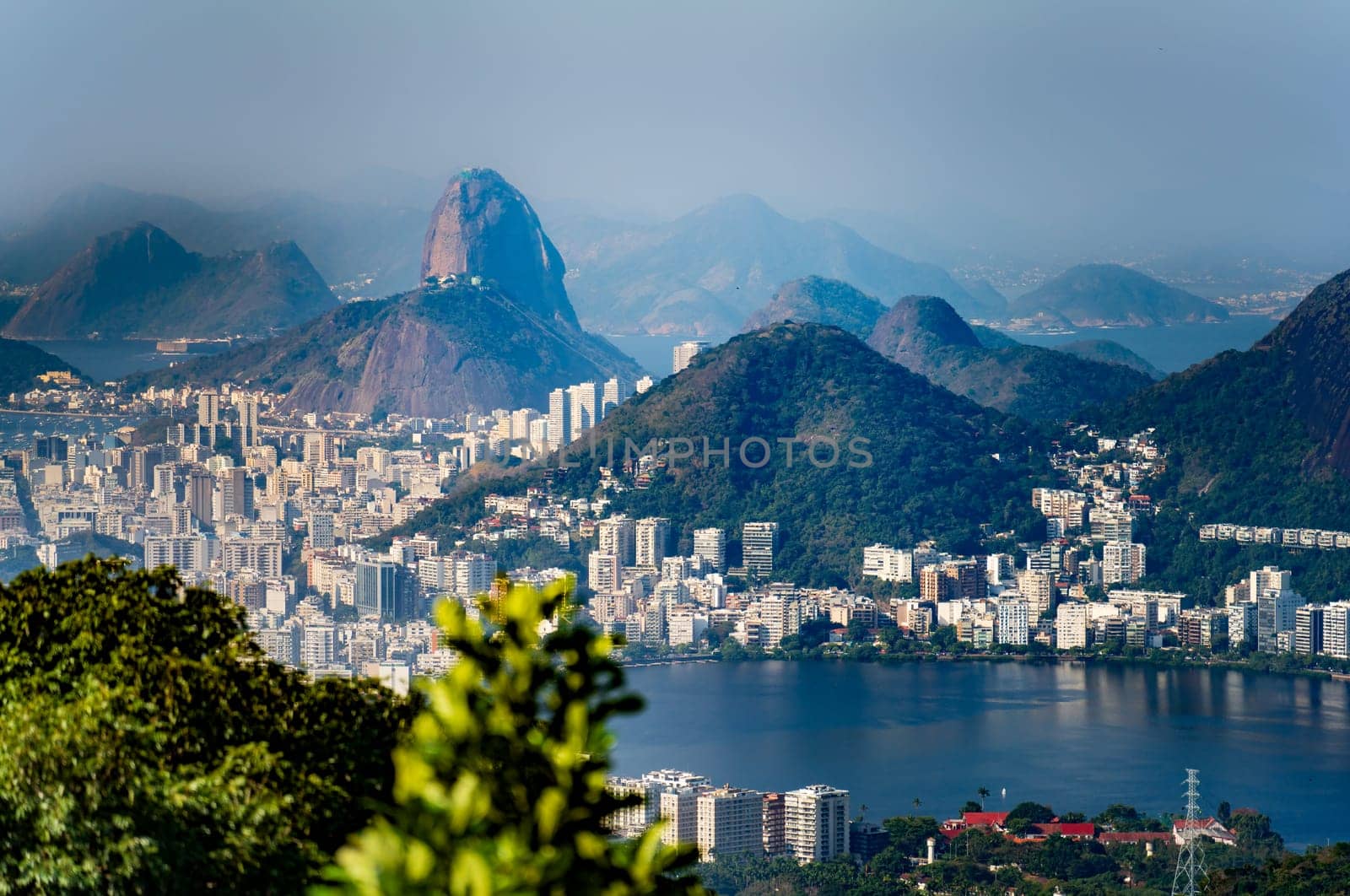 Distant view of Rio's Lagoa, skyline and Sugarloaf Mountain in evening mist.