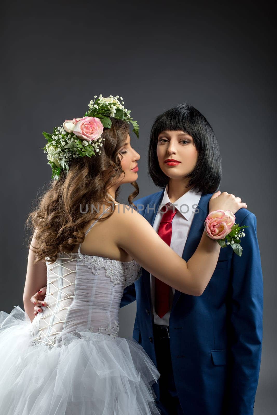 Image of lesbian bride and groom posing at camera
