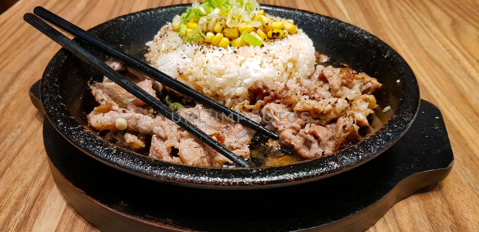 selective focus grilled beef steak with korean sauce bulgogi on top of rice with slice of pepper and sweet corn - korean food style