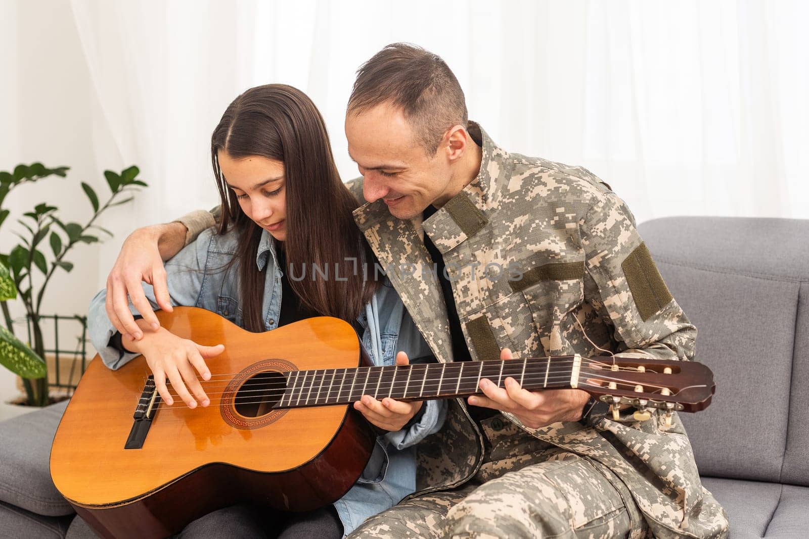a veteran and his daughter play the guitar by Andelov13