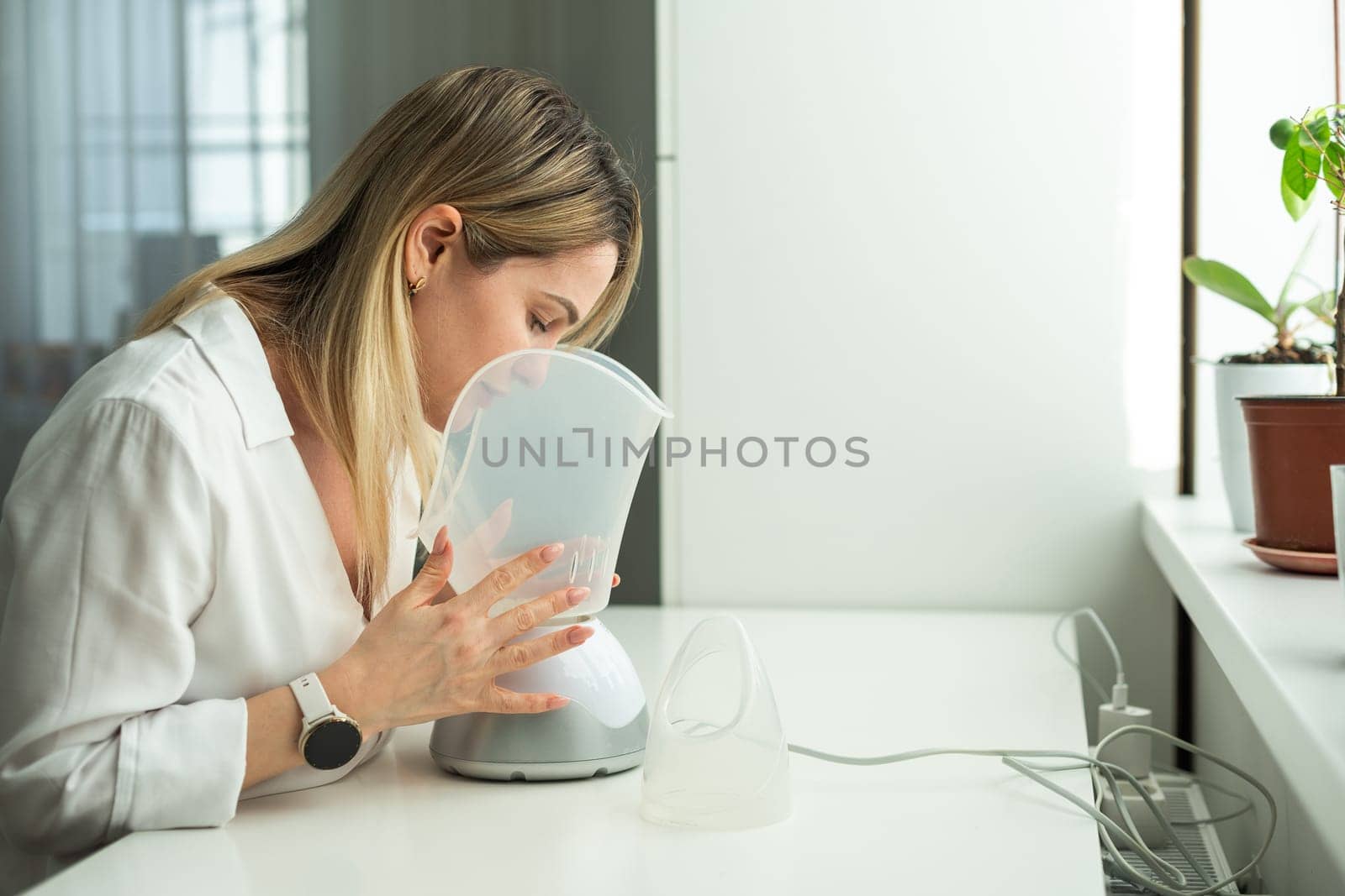 Woman has a bad cold and is trying therapy by inhaler. High quality photo
