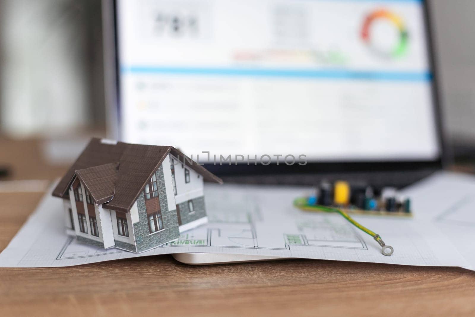 A real estate model and a computer are on the table. High quality photo