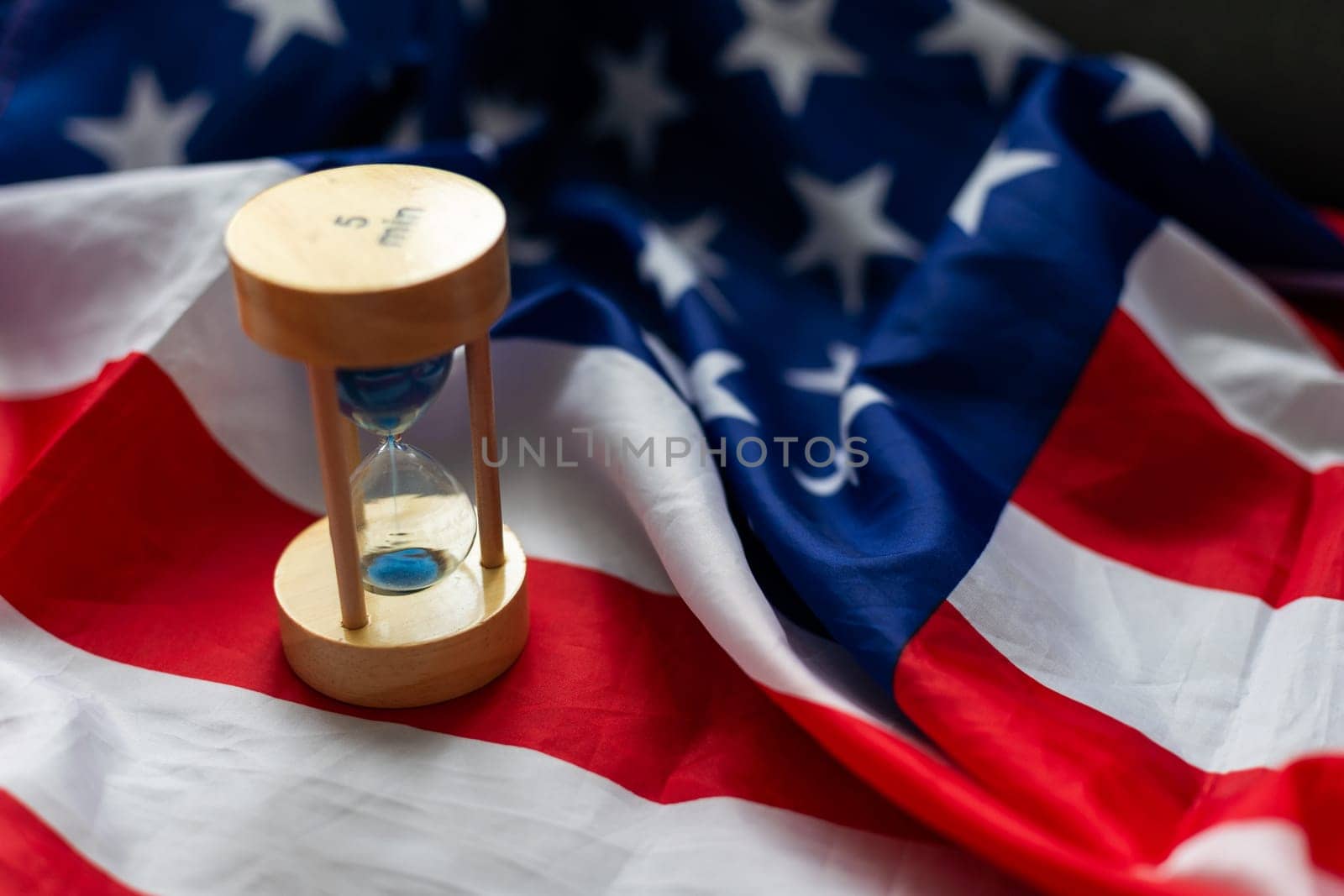 Hourglass and USA flag, soft focus, copy space. High quality photo