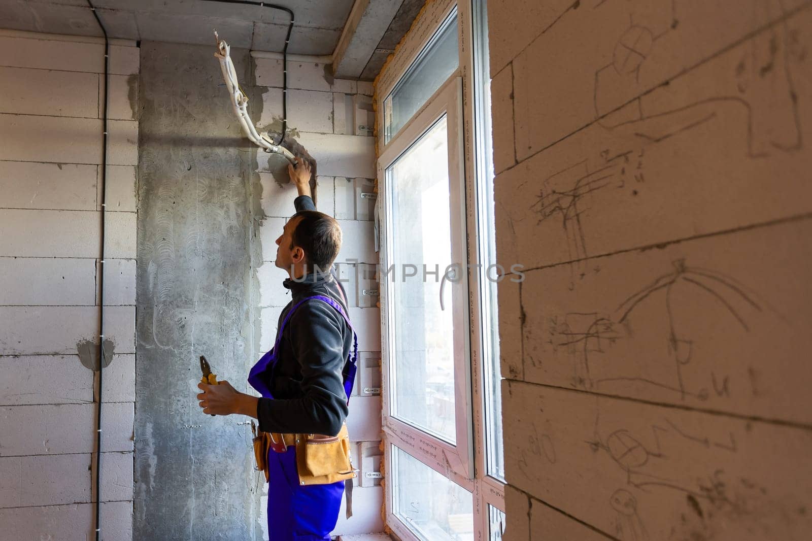Builder fitting insulation fibre to room walls.
