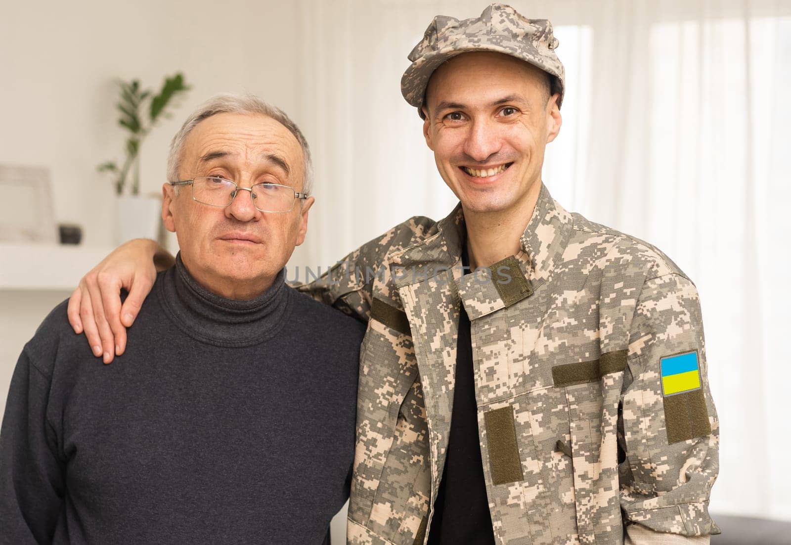 Soldier in military uniform reunited with his family and Ukrainian flag.