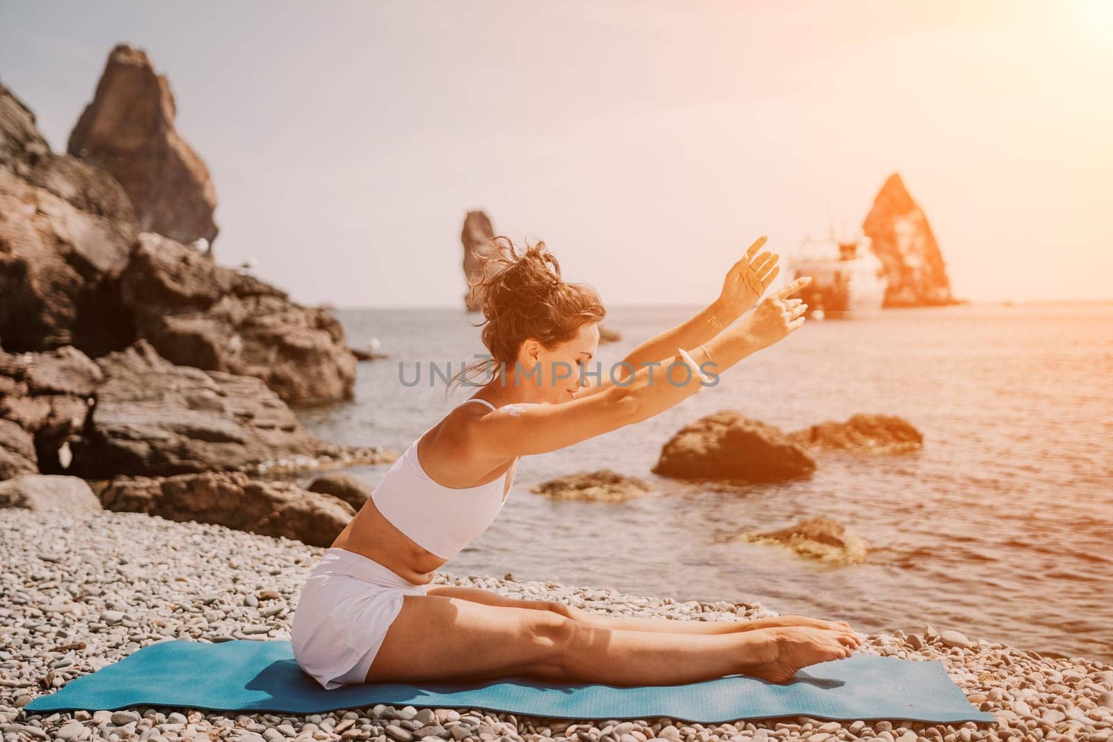 Woman sea yoga. Two Happy women meditating in yoga pose on the beach, ocean and rock mountains. Motivation and inspirational fit and exercising. Healthy lifestyle outdoors in nature, fitness concept. by panophotograph