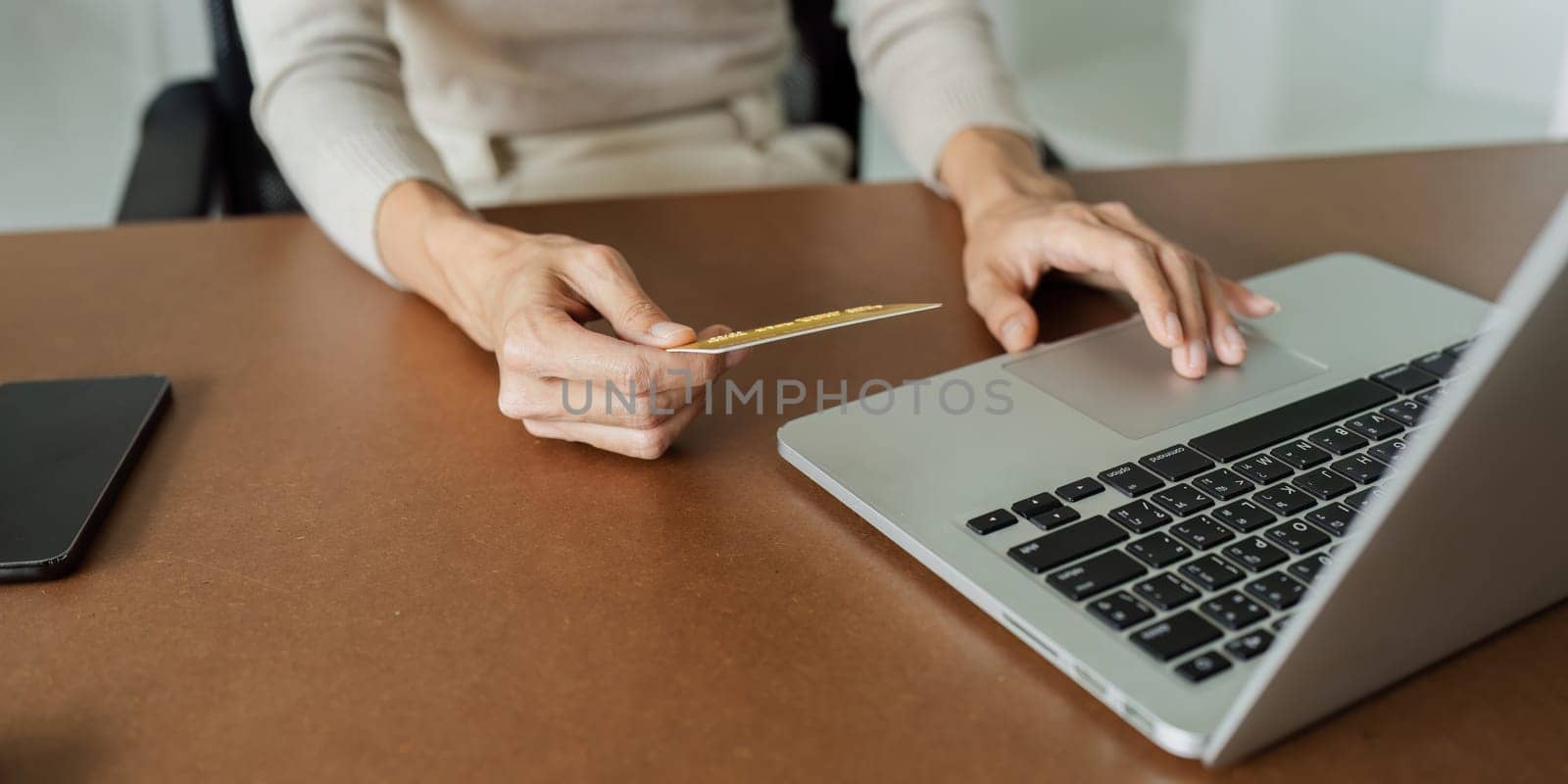 Young woman makes a purchase on the Internet on the laptop with credit card.