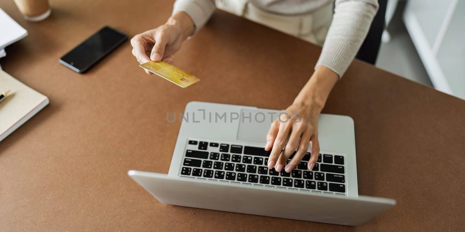 Young woman makes a purchase on the Internet on the laptop with credit card.