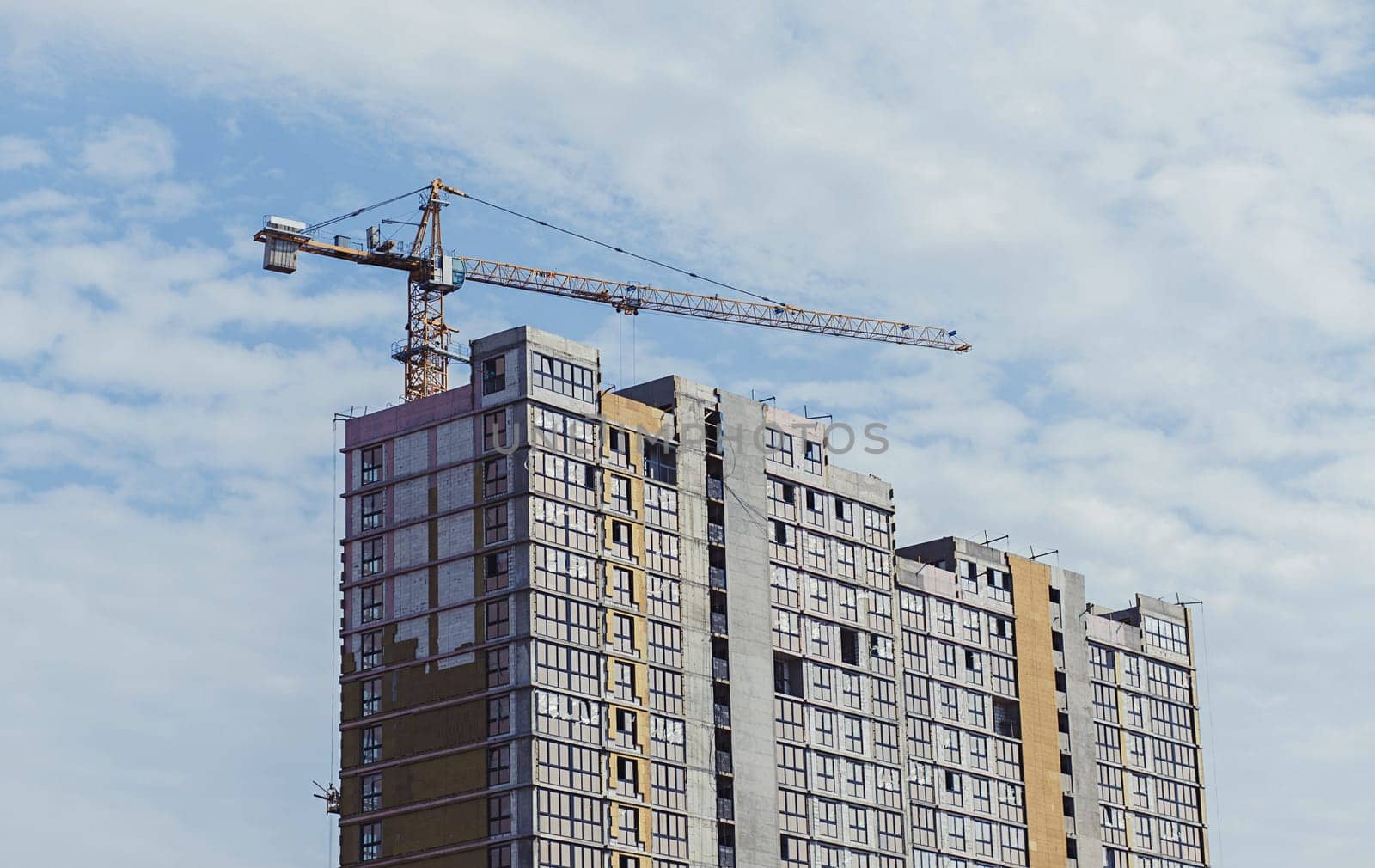 Construction site with crane and building on sky background