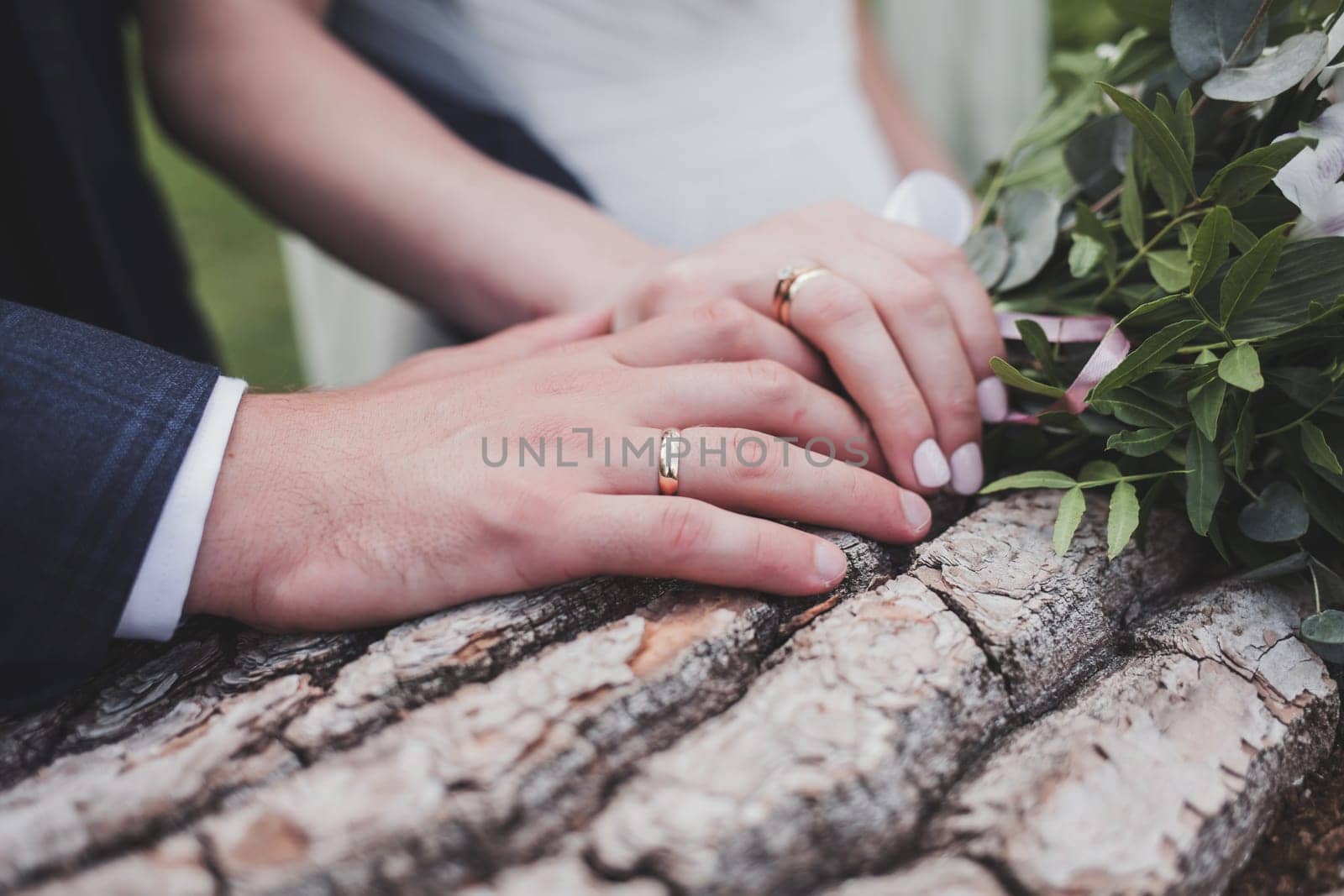 Hands of newlyweds with wedding rings. Rustic style