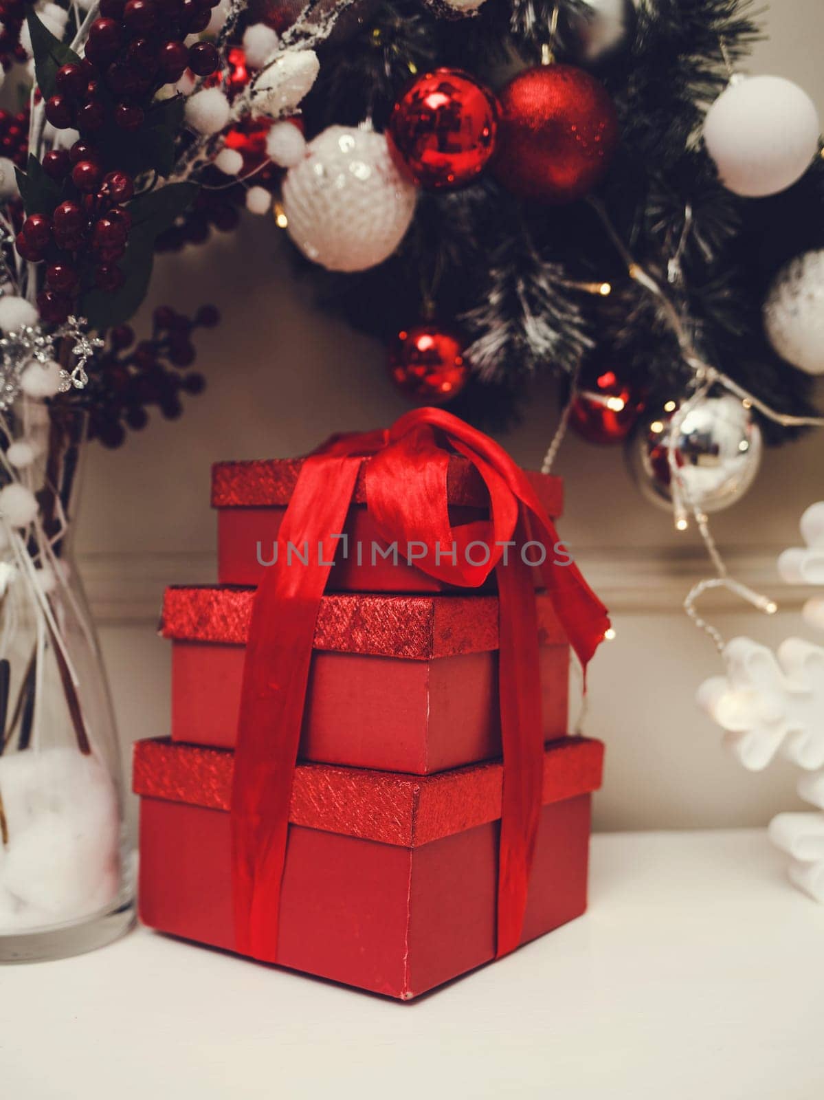 Gift boxes with big red ribbon on background of twinkling lights.  Luxury new year gift. Christmas gift.