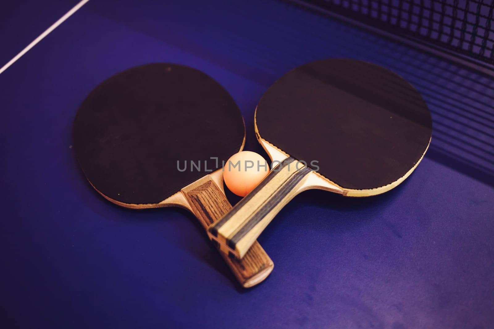 table tennis ping pong two paddles and ball on blue board. sport concept