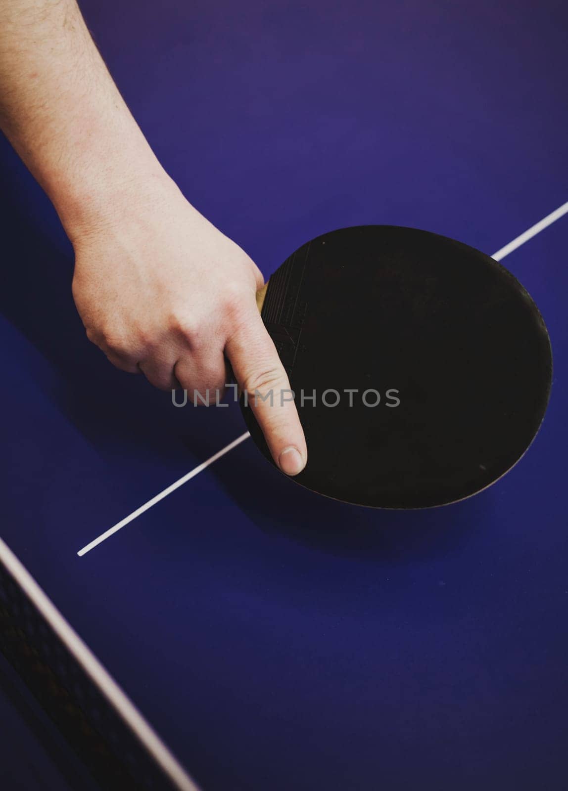 professional ping pong player. hand with a tennis racket on the background of the board