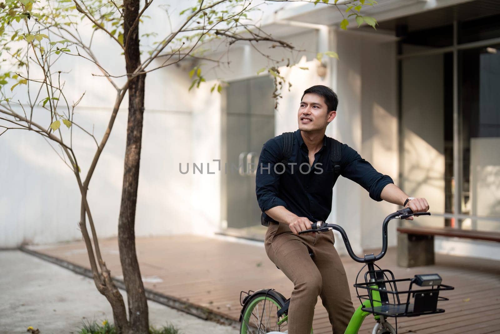 Businessman and bicycle in city to work with eco friendly transport. happy businessman professional riding a bicycle in urban street by nateemee