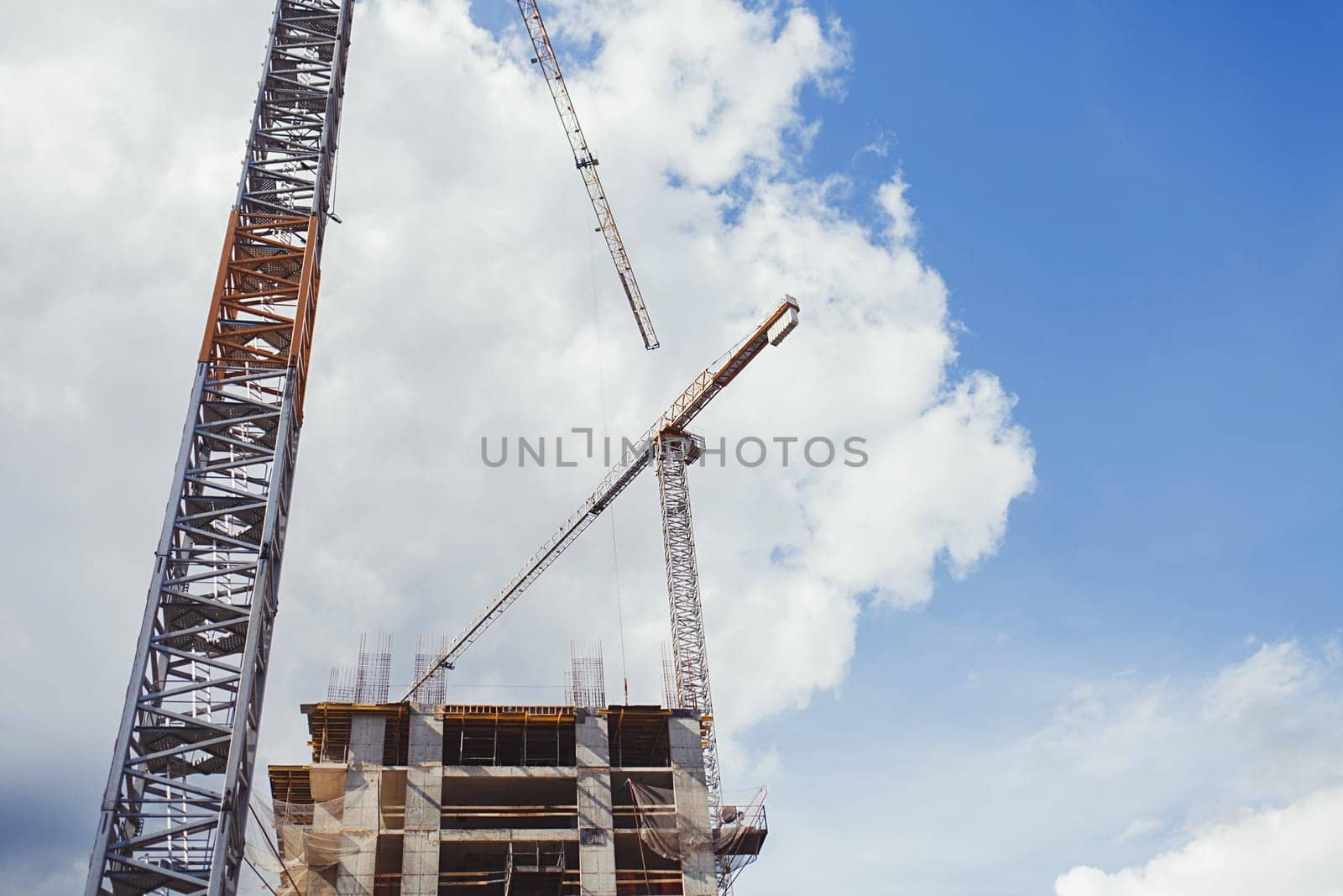 Construction site with cranes on blue sky background