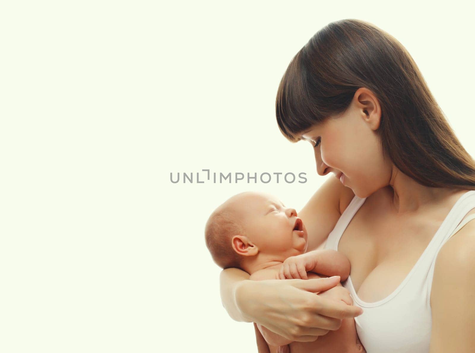 Happy young mother holding cute infant, baby sleeping in arms on white studio background