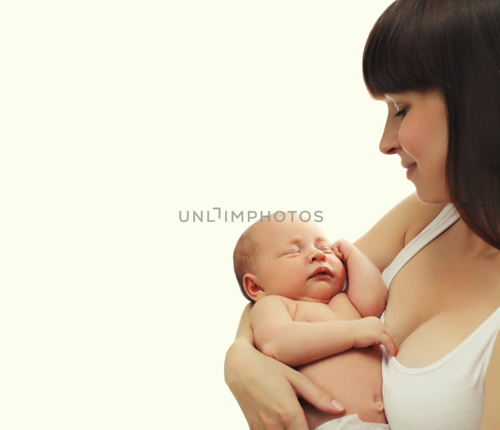 Happy young mother holding cute infant, baby sleeping in arms on white studio background