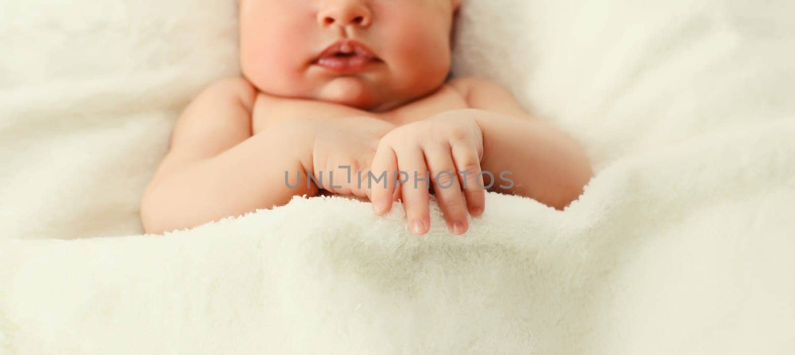 Close up portrait of infant sweet sleeping lying on white bed at home