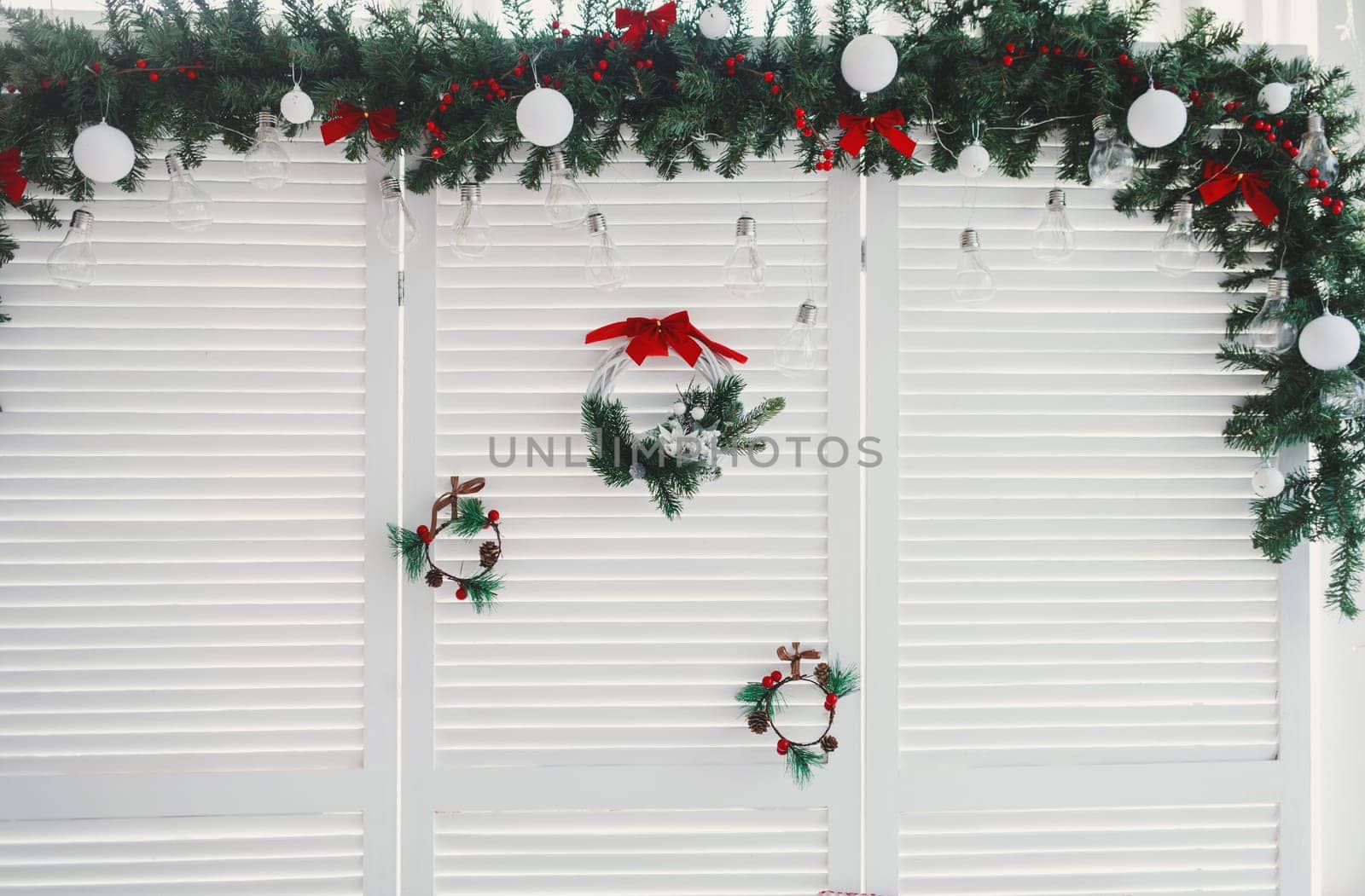 Christmas composition with green pine branches, hanging red ornaments