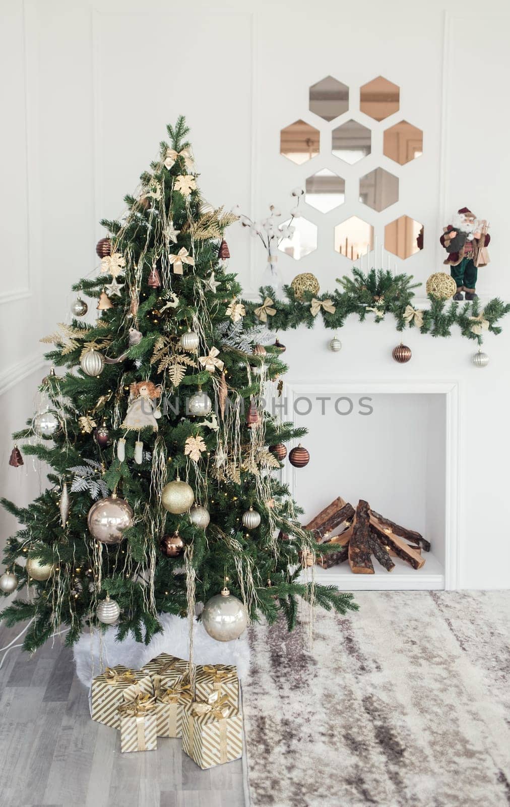 Cozy beautiful modern design of the room in light colors decorated with Christmas tree and decorative elements fireplace