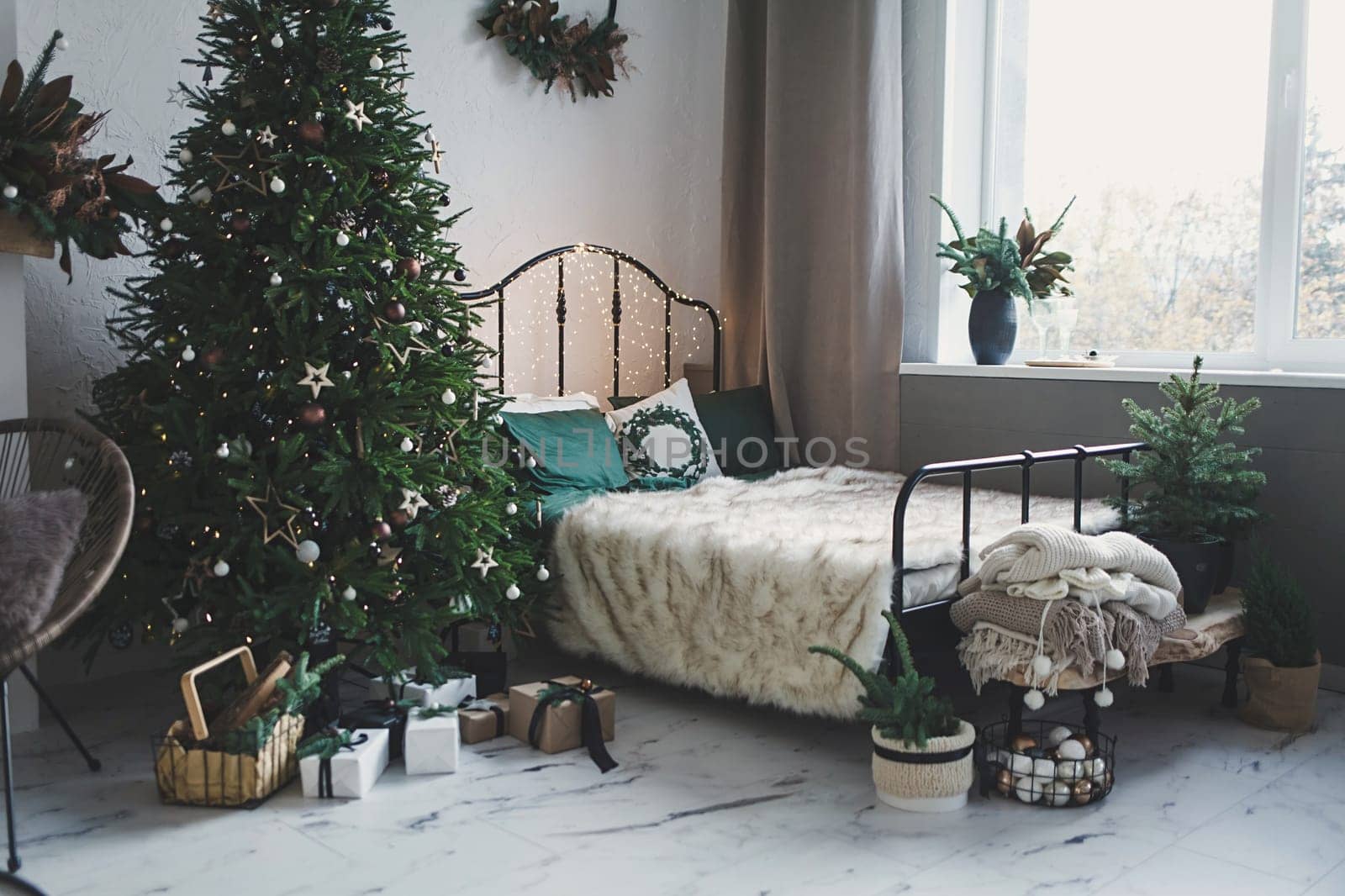 Classic Christmas interior with a decorated tree. Vintage bed and tree with gifts