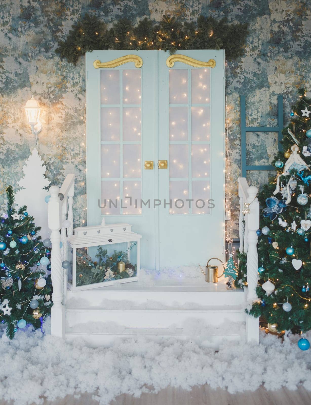 Vintage door with Christmas decorations. Winter terrace of the house with garlands of retro light bulbs
