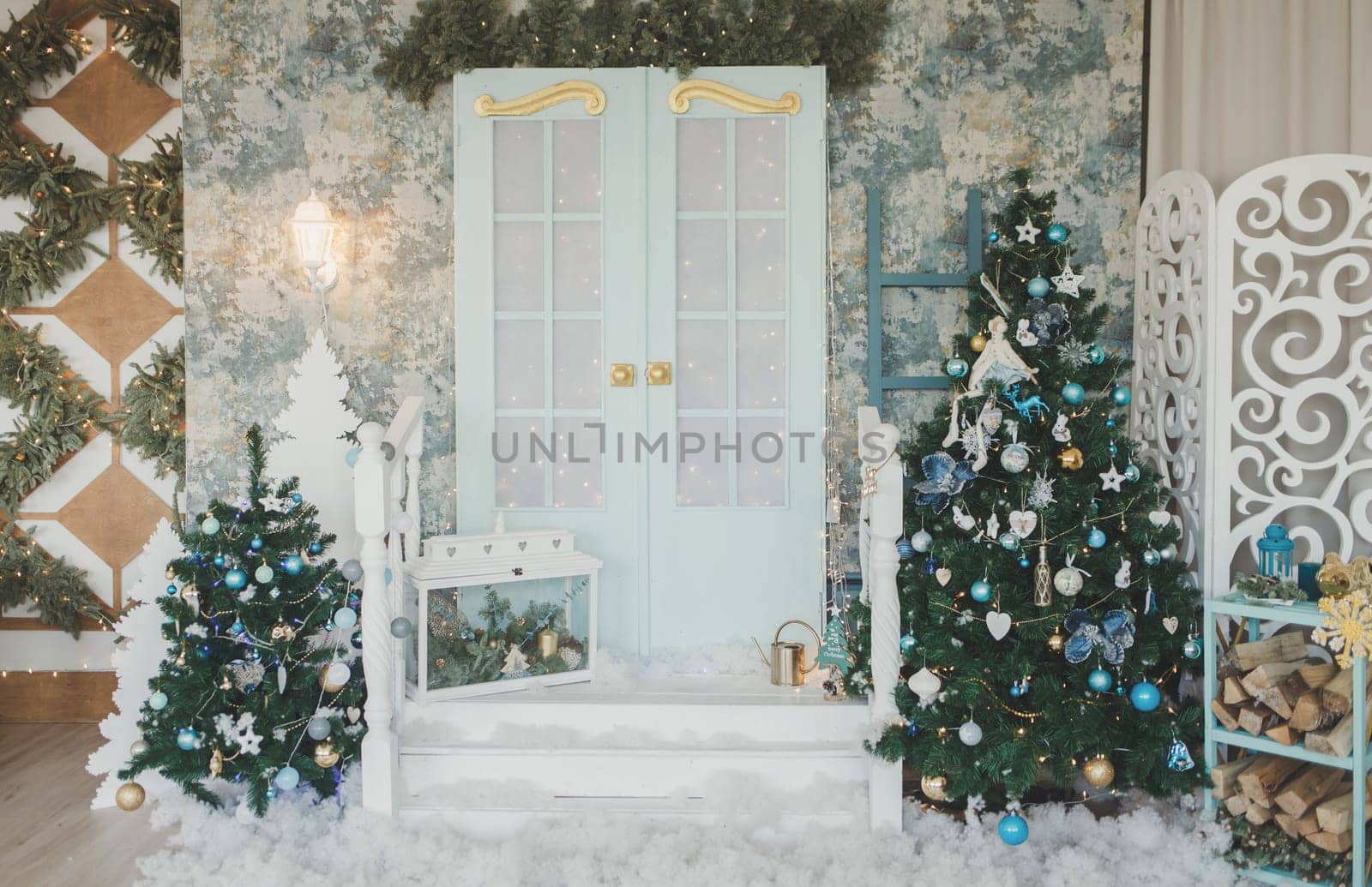 Porch with door in Christmas decorations and Christmas trees. Spruce garlands around the door. 