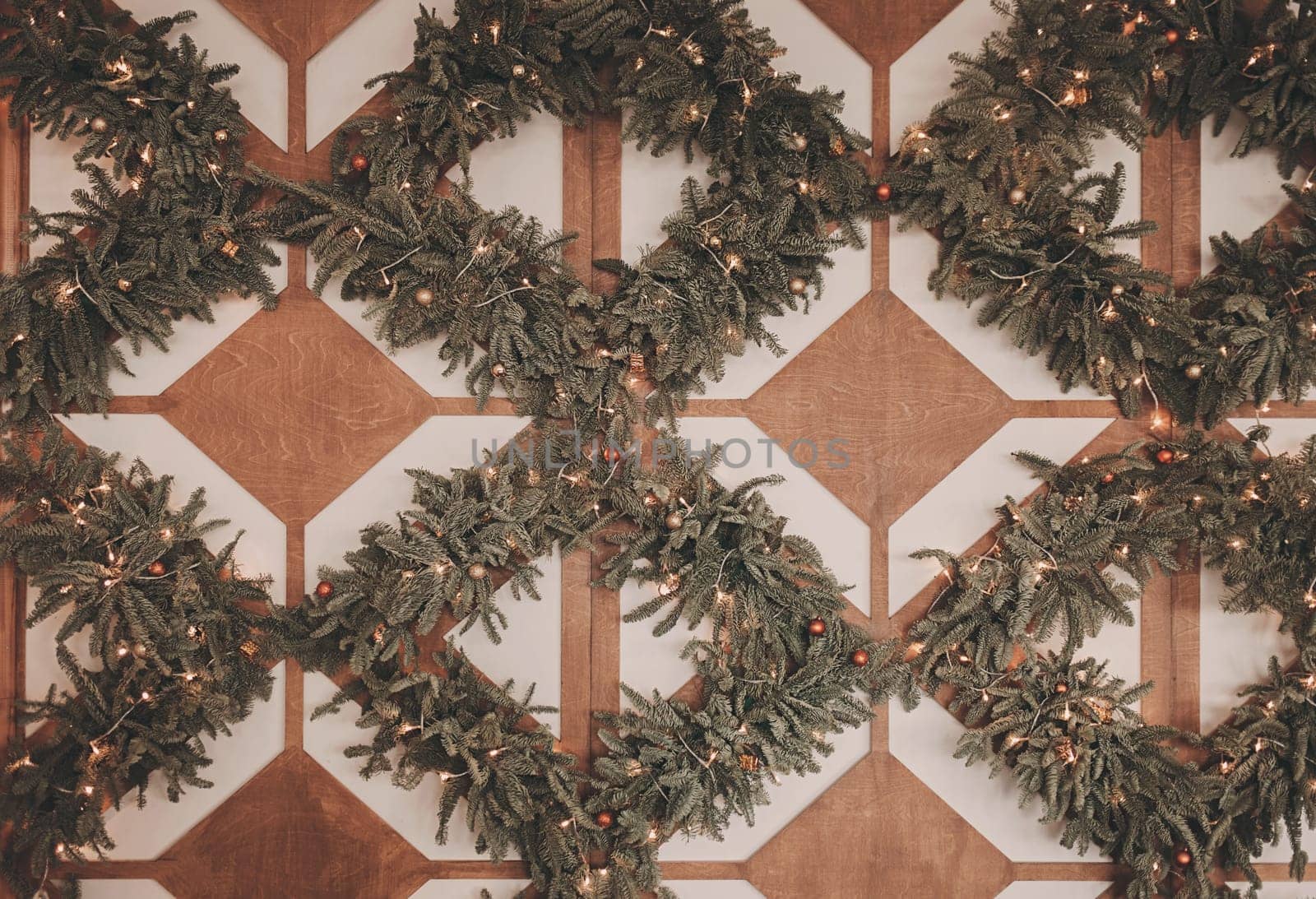 elegantly decorated Christmas wall with Christmas tree branches and lights