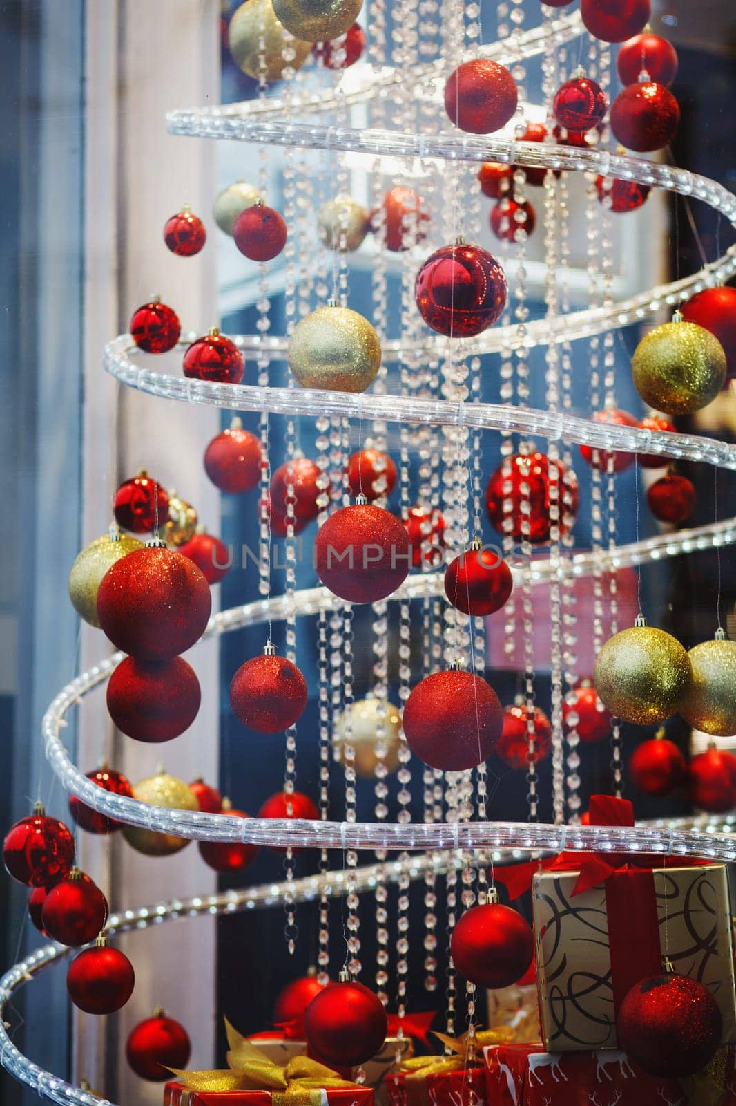 a lot of red hanging balls on the shop window decorated for Christmas